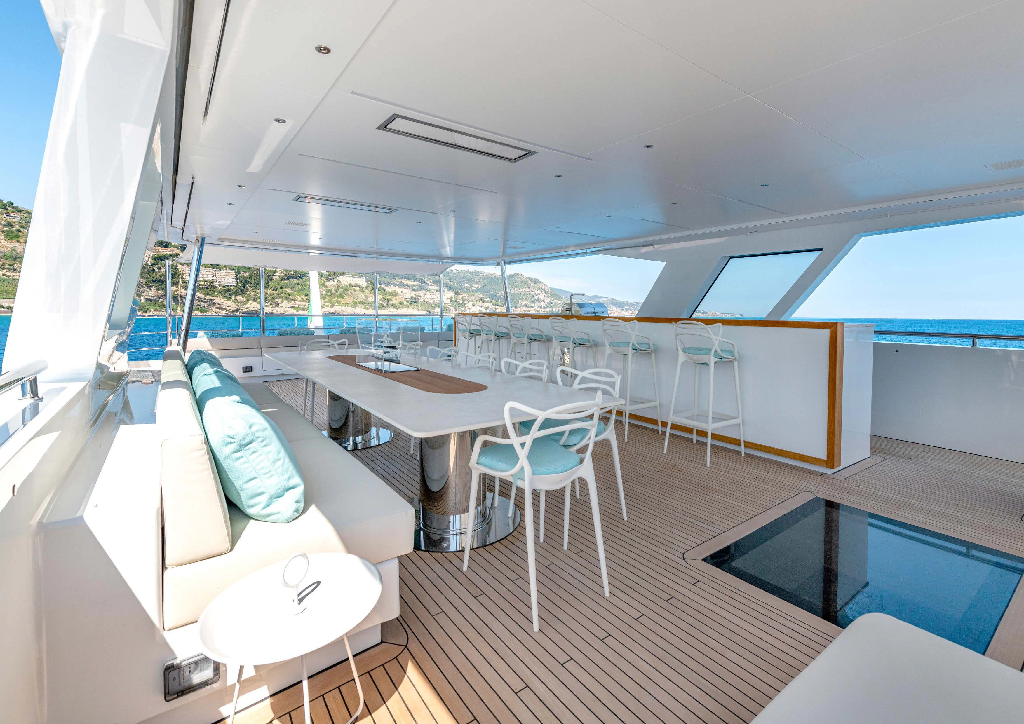a room with a deck and chairs aboard CARITA Yacht for Sale