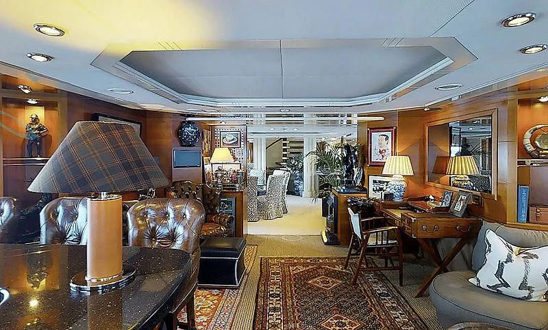 a living room with a large chandelier and a table aboard TURQUOISE Yacht for Sale