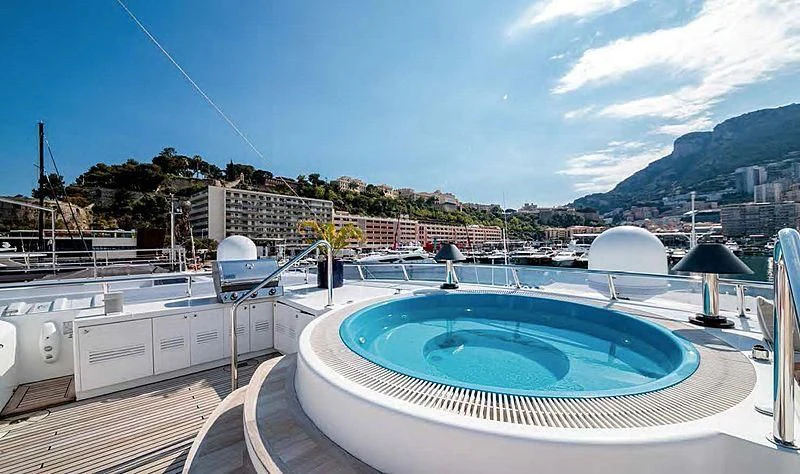 a large pool with a city in the background aboard TURQUOISE Yacht for Sale