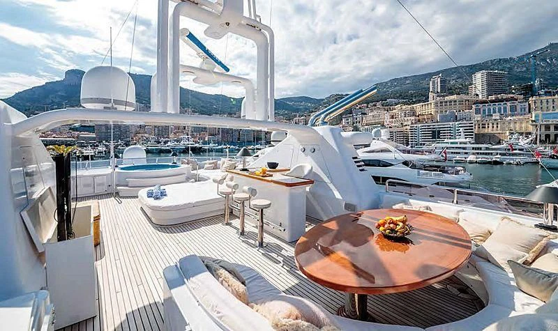 a table with chairs on it next to a large body of water aboard TURQUOISE Yacht for Sale