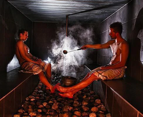 a couple of men in a room with a fire aboard XUMI Yacht for Charter