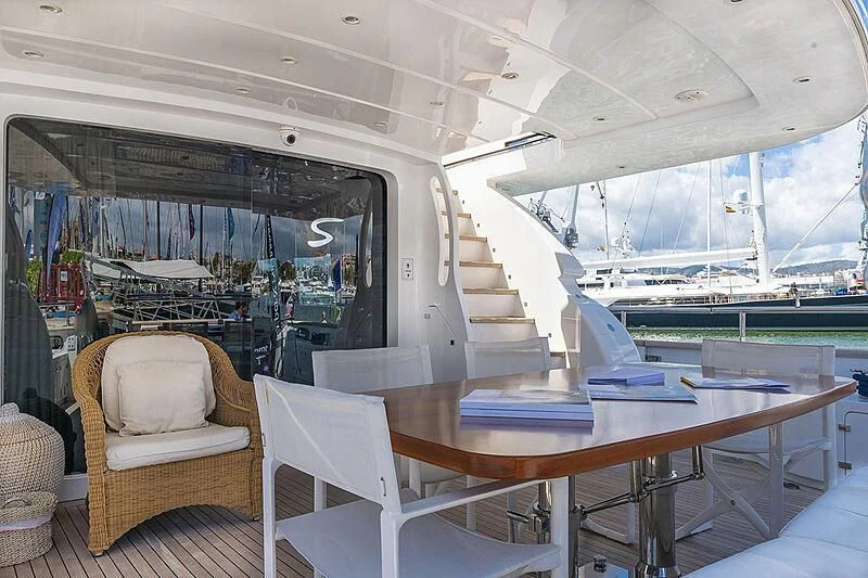 a room with a table chairs and a large window aboard XUMI Yacht for Charter