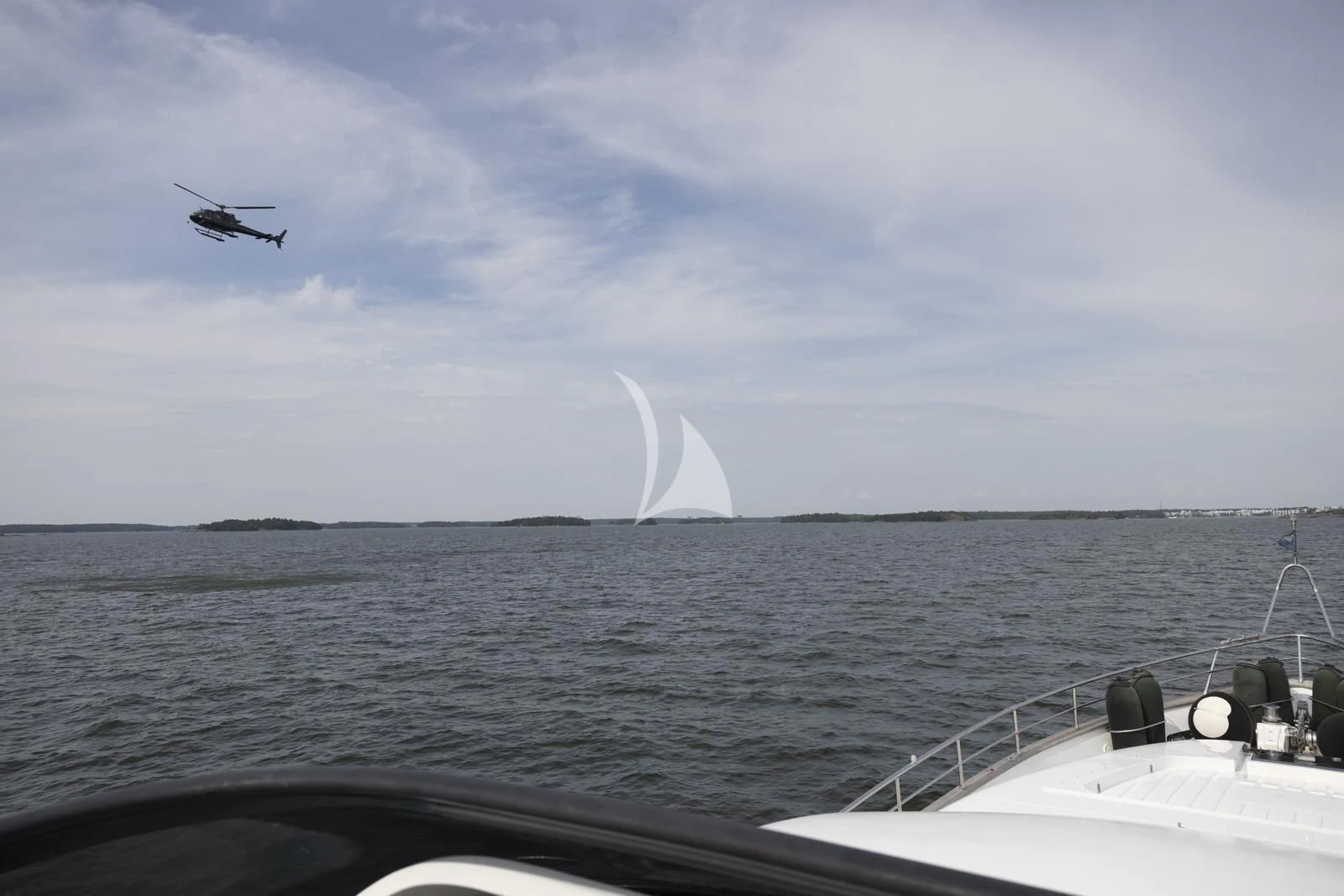 a helicopter flying over the ocean aboard XUMI Yacht for Charter