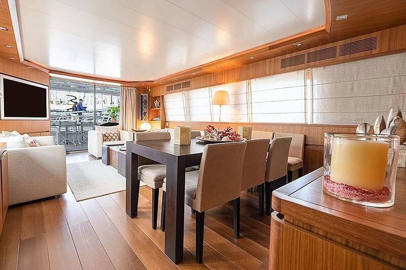 a large room with a table and chairs aboard XUMI Yacht for Charter