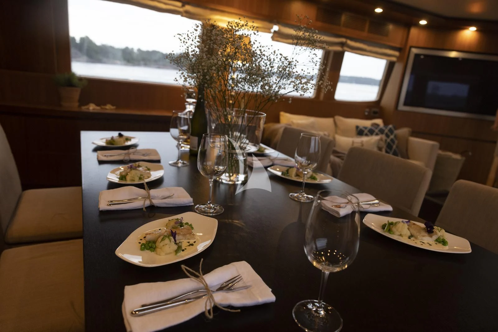 a table with plates and glasses on it aboard XUMI Yacht for Charter