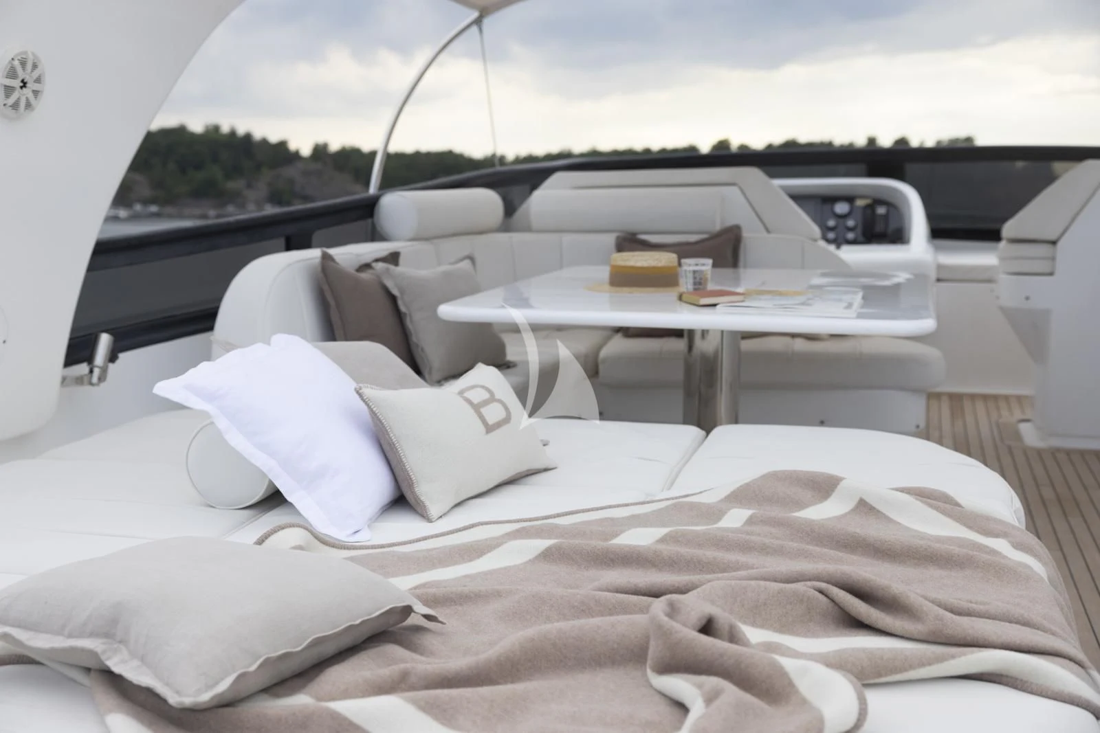 a bed with pillows and a table aboard XUMI Yacht for Charter