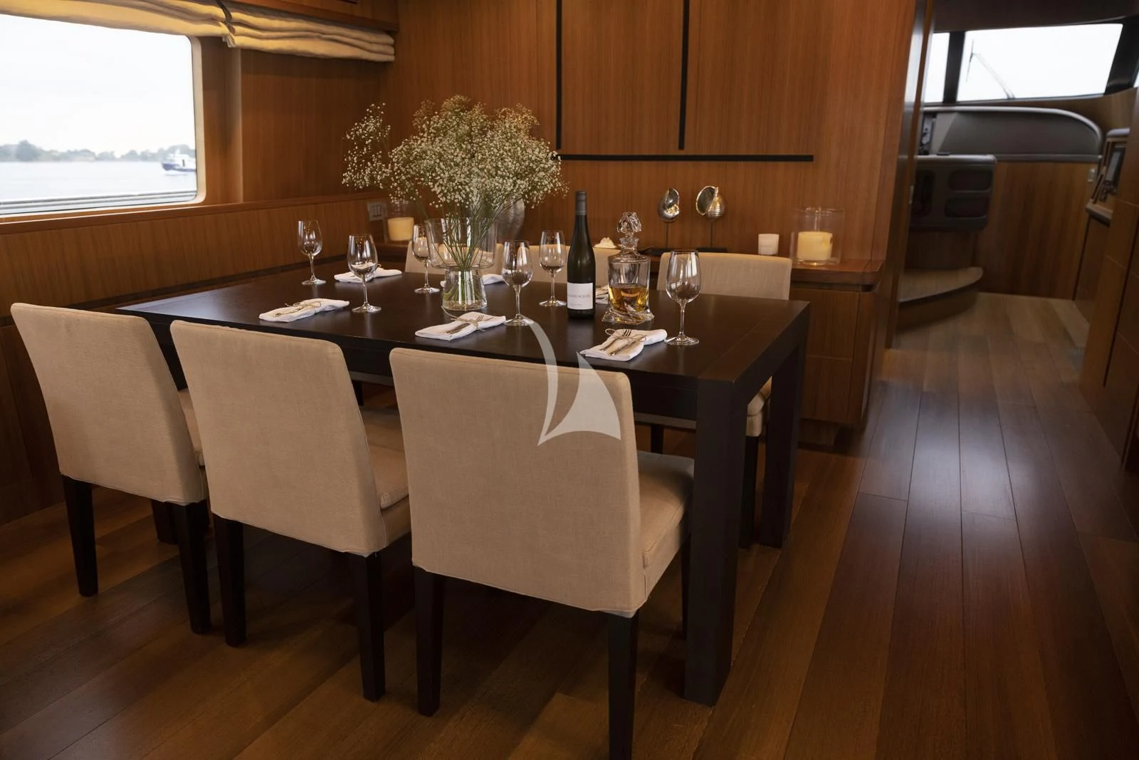 a table with wine glasses and bottles on it aboard XUMI Yacht for Charter