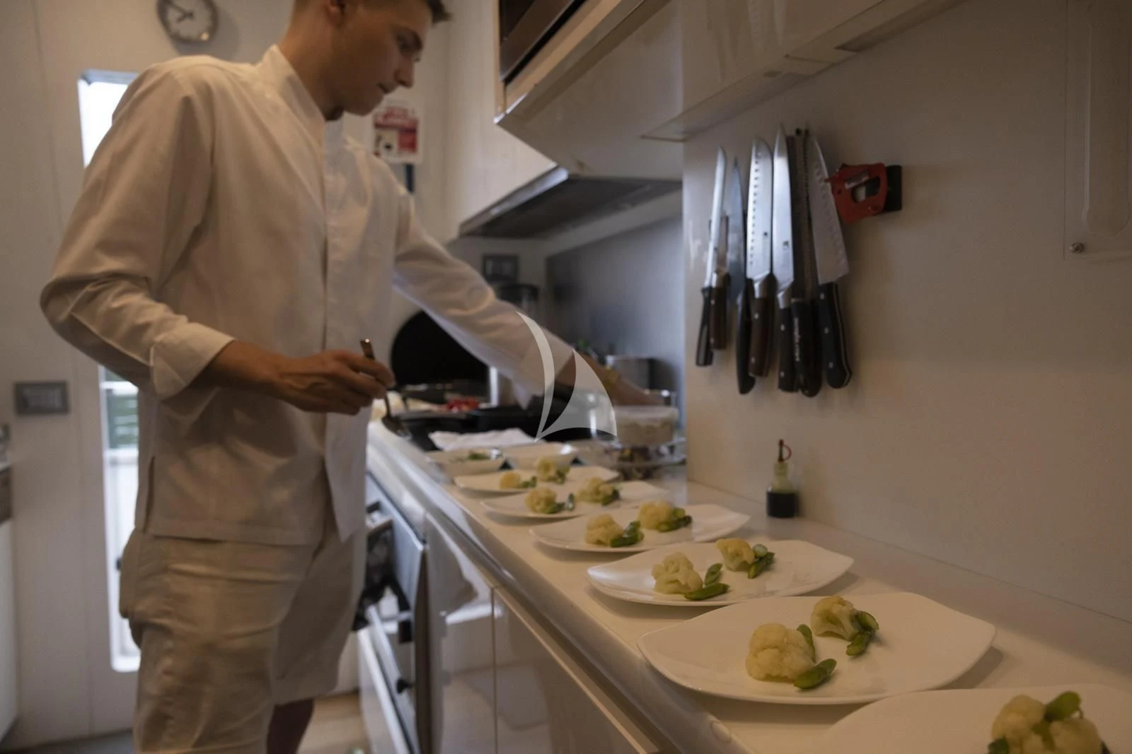 a person preparing food in a kitchen aboard XUMI Yacht for Charter