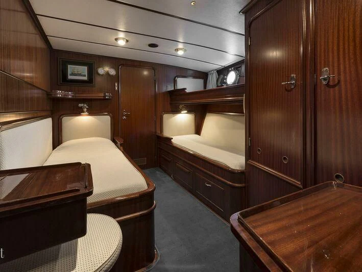 a room with a bed and a desk aboard FIVE ANGELS Yacht for Sale