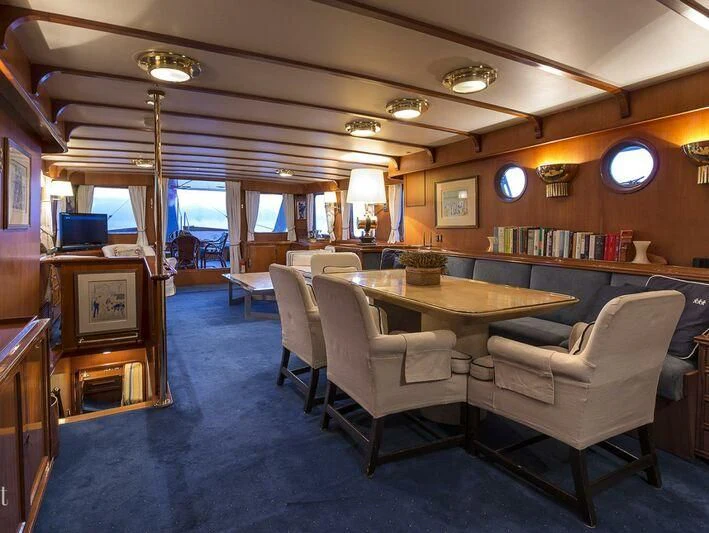 a room with a table chairs and a window aboard FIVE ANGELS Yacht for Sale