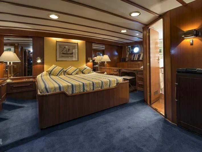 a bedroom with a bed and a desk aboard FIVE ANGELS Yacht for Sale