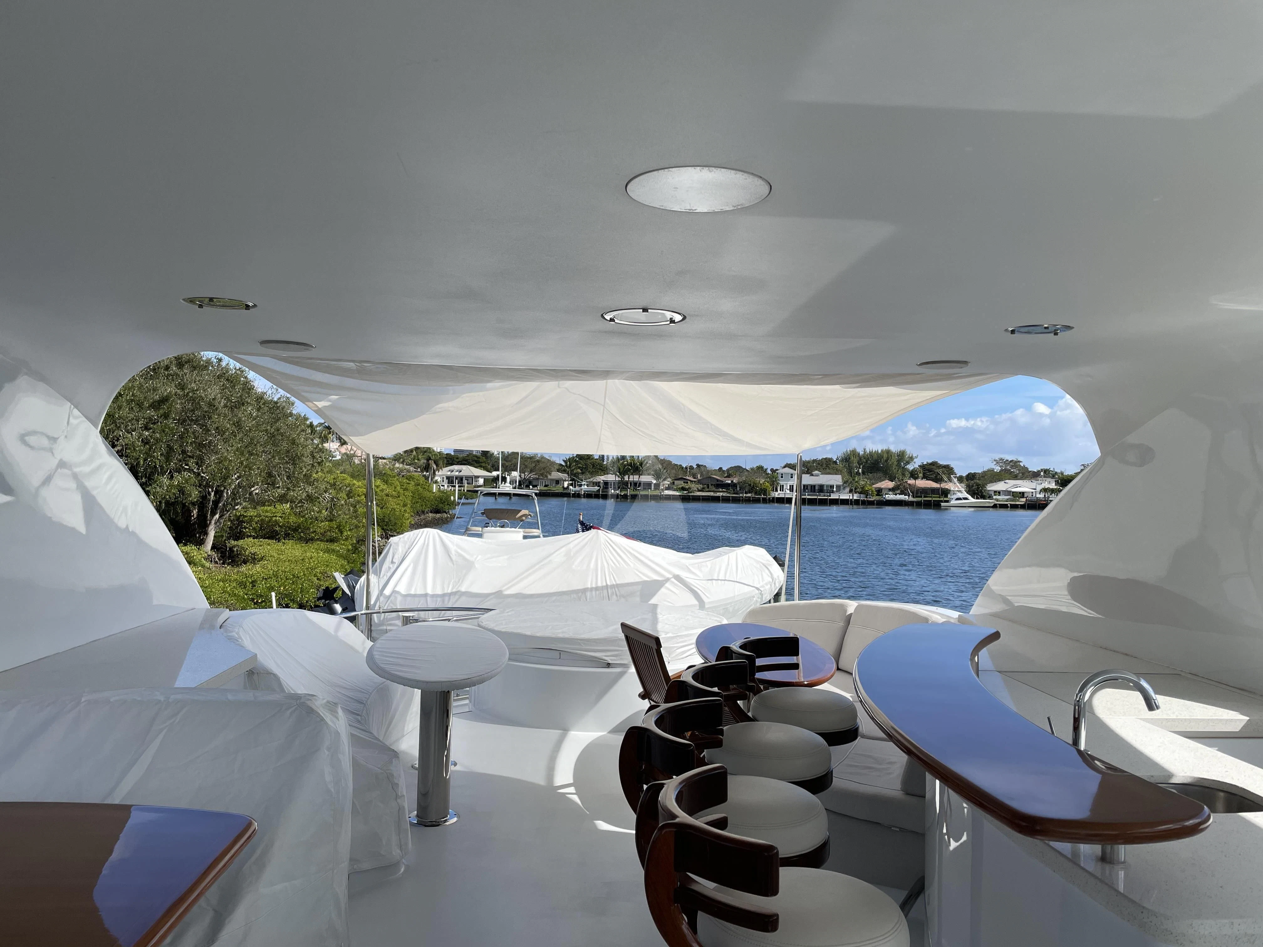 a room with a table chairs and a view of a body of water aboard CENTER RING Yacht for Sale