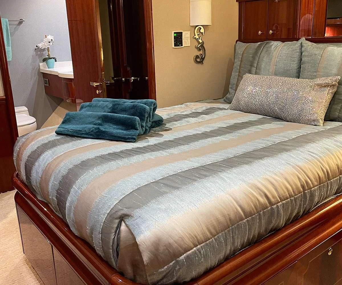 a bed with a blue blanket aboard CENTER RING Yacht for Sale