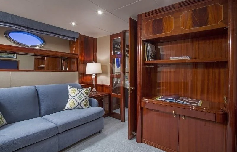a living room with a couch and a book shelf aboard CENTER RING Yacht for Sale
