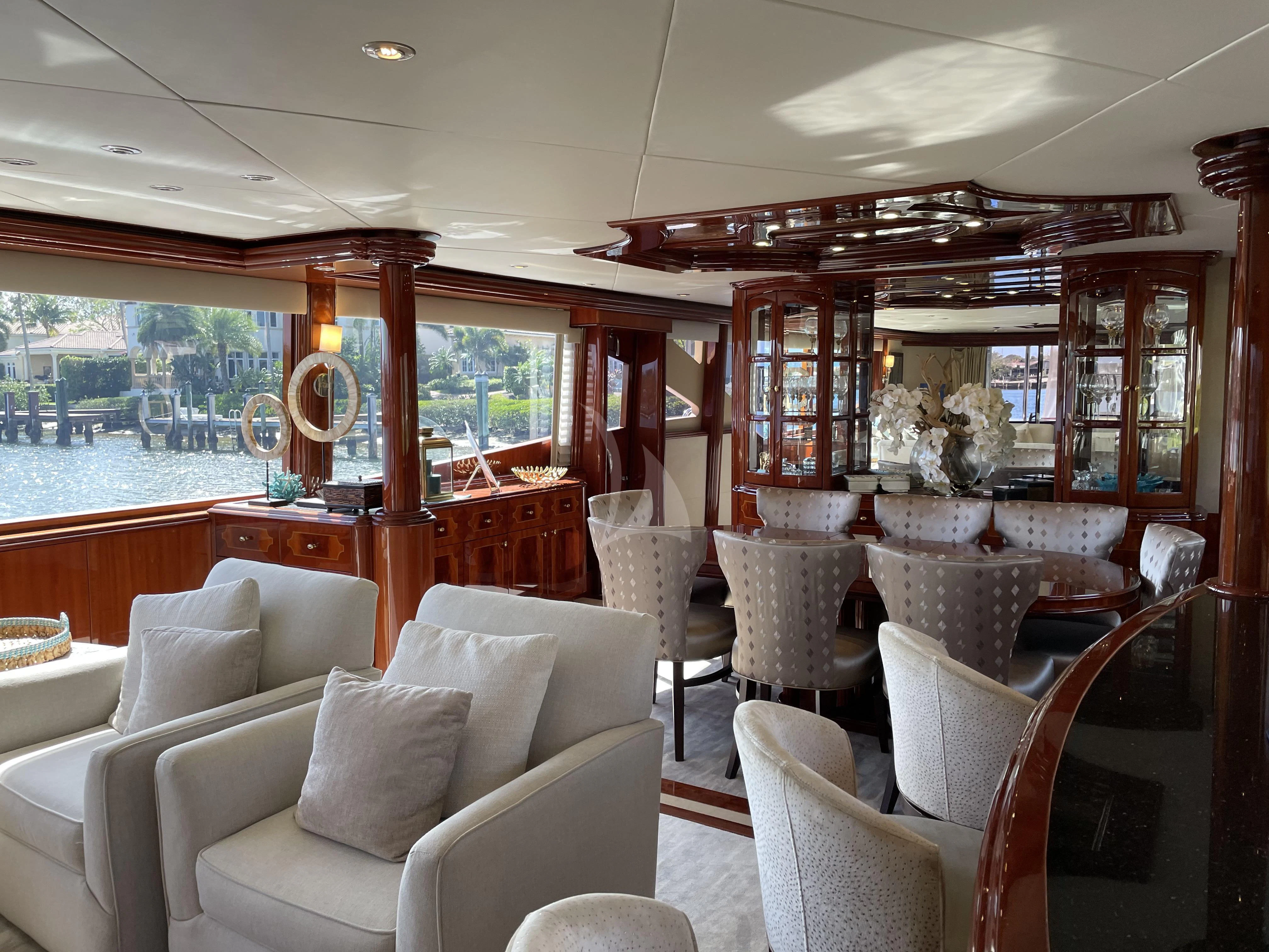 a room with a large window and a table with chairs aboard CENTER RING Yacht for Sale