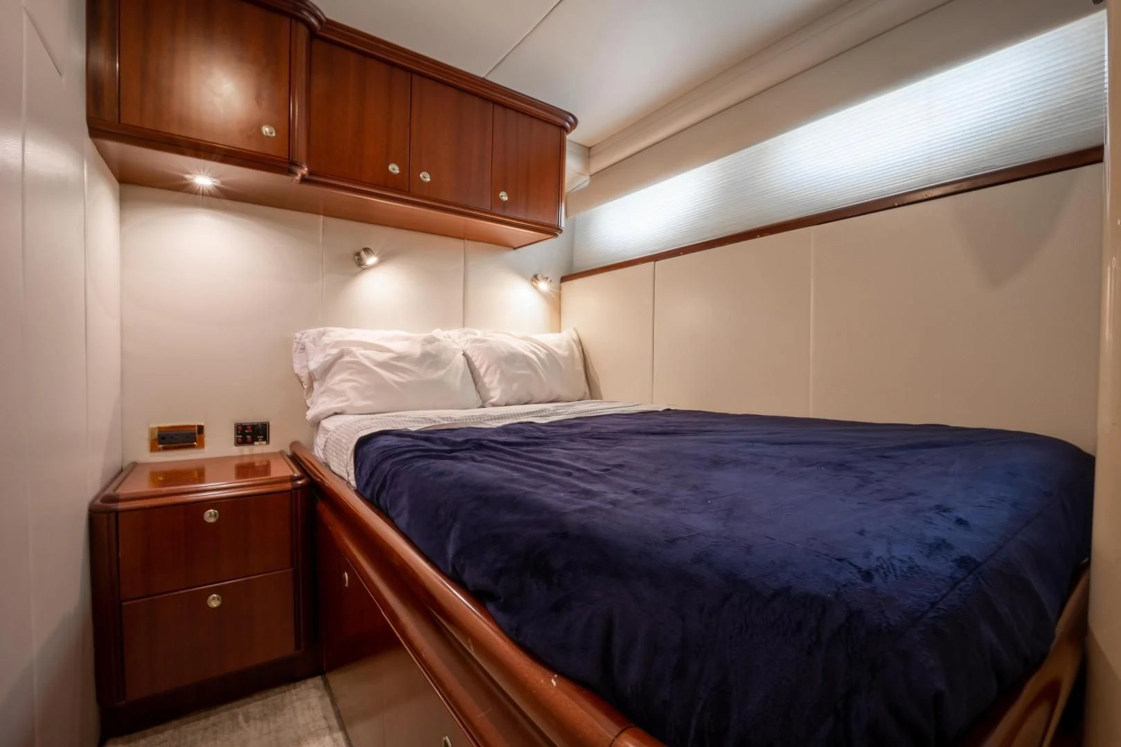 a bedroom with a bed and a dresser aboard CENTER RING Yacht for Sale