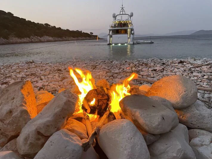 a fire on a beach aboard MIAMAA Yacht for Sale