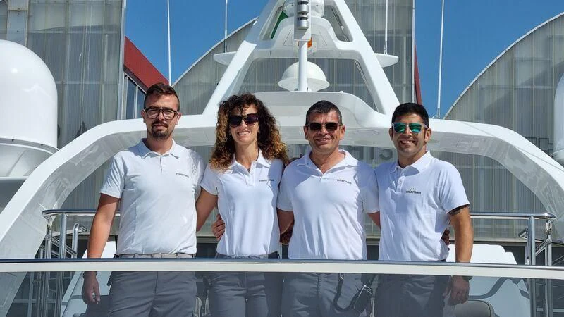 a group of people posing for a photo on a boat aboard MIAMAA Yacht for Sale