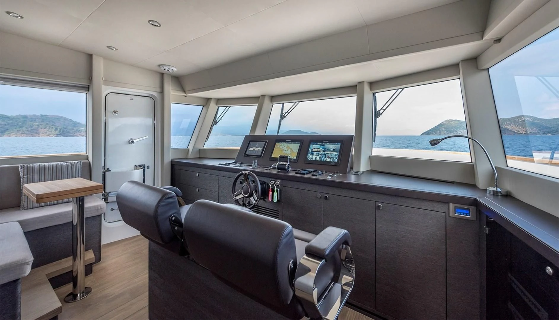 inside of a vehicle with a desk and chairs and a window aboard NUMARINE 26XP/24 Yacht for Sale