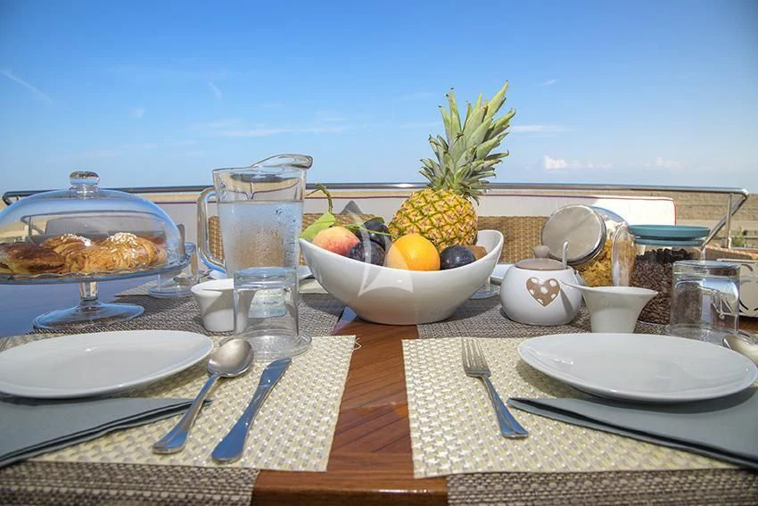 a table with plates and glasses aboard ANNE MARIE Yacht for Sale