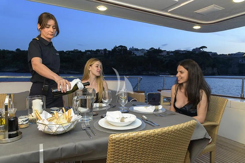 a couple of women sitting at a table with food and drinks aboard ANNE MARIE Yacht for Sale