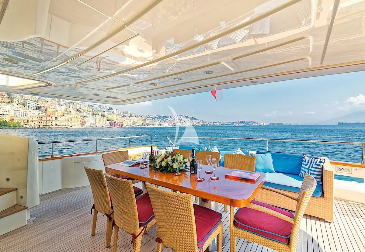 a table and chairs on a deck overlooking a large body of water aboard ANNE MARIE Yacht for Sale