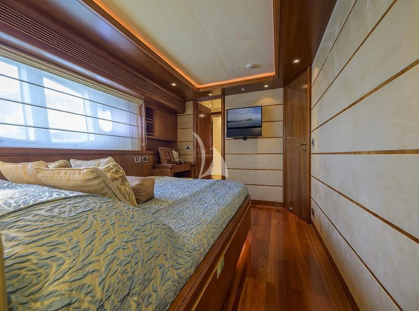 a bedroom with a bed and a television on the wall aboard ANNE MARIE Yacht for Sale