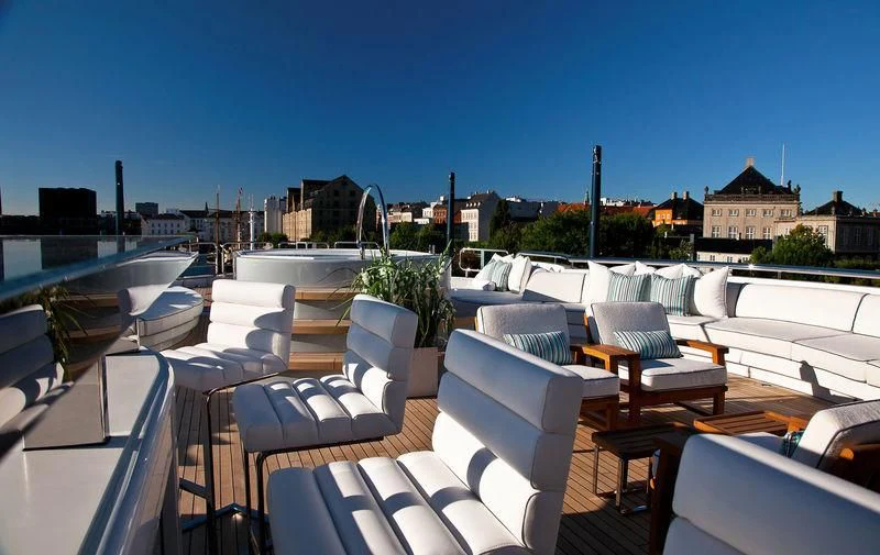a patio with chairs and tables aboard ODESSA II Yacht for Sale
