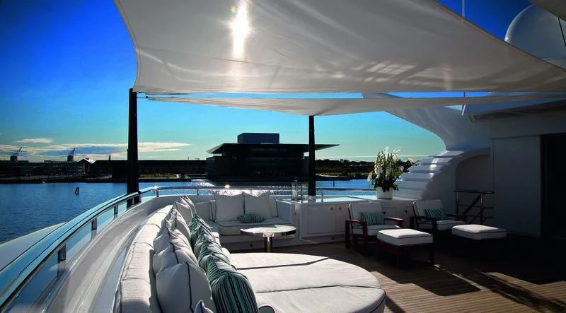 a large swimming pool with a large deck and lounge chairs aboard ODESSA II Yacht for Sale