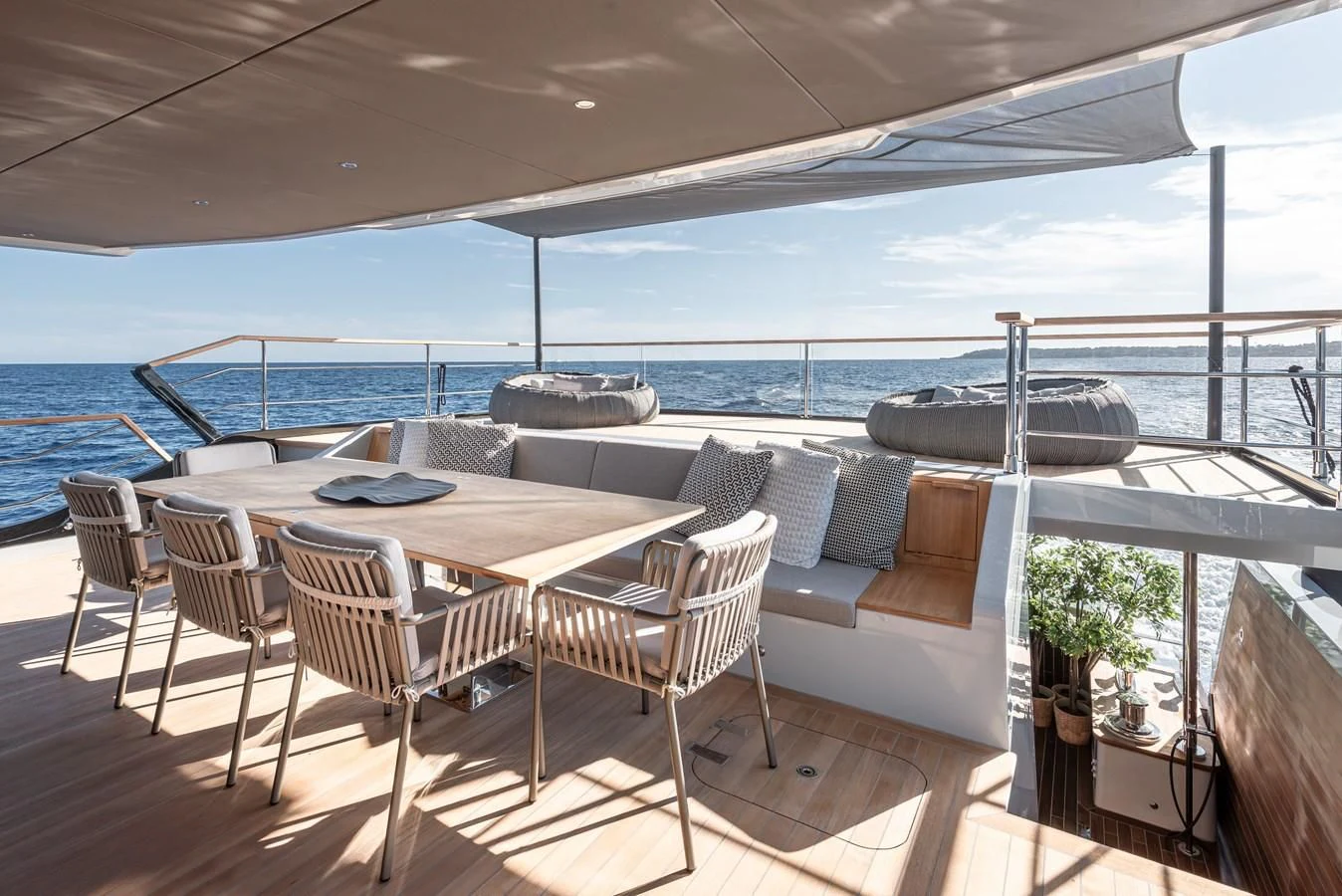 a table and chairs on a deck overlooking a body of water aboard TUCCINI Yacht for Sale