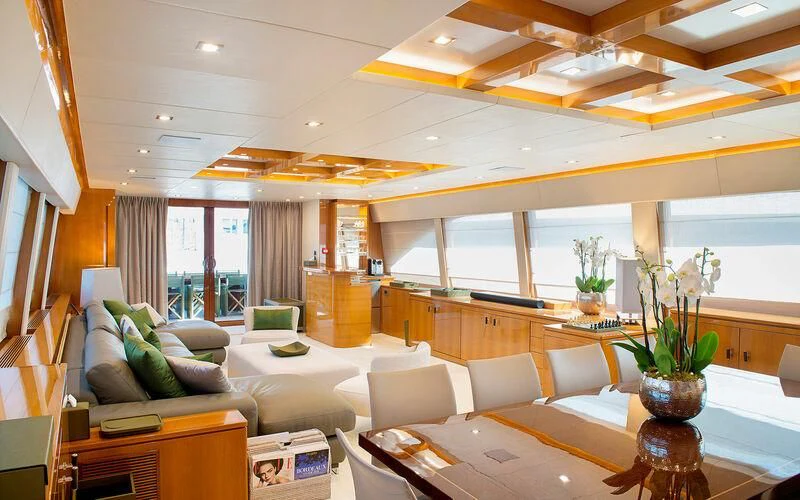 a room with a couch and a table and a window aboard APMONIA Yacht for Sale