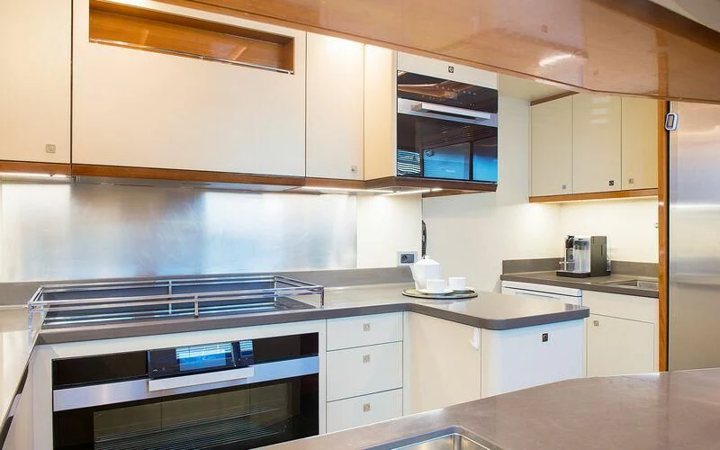 a kitchen with white cabinets aboard APMONIA Yacht for Sale