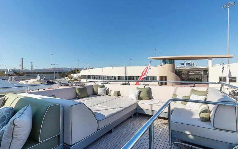 a deck with a view of a boat and a flag on it aboard APMONIA Yacht for Sale