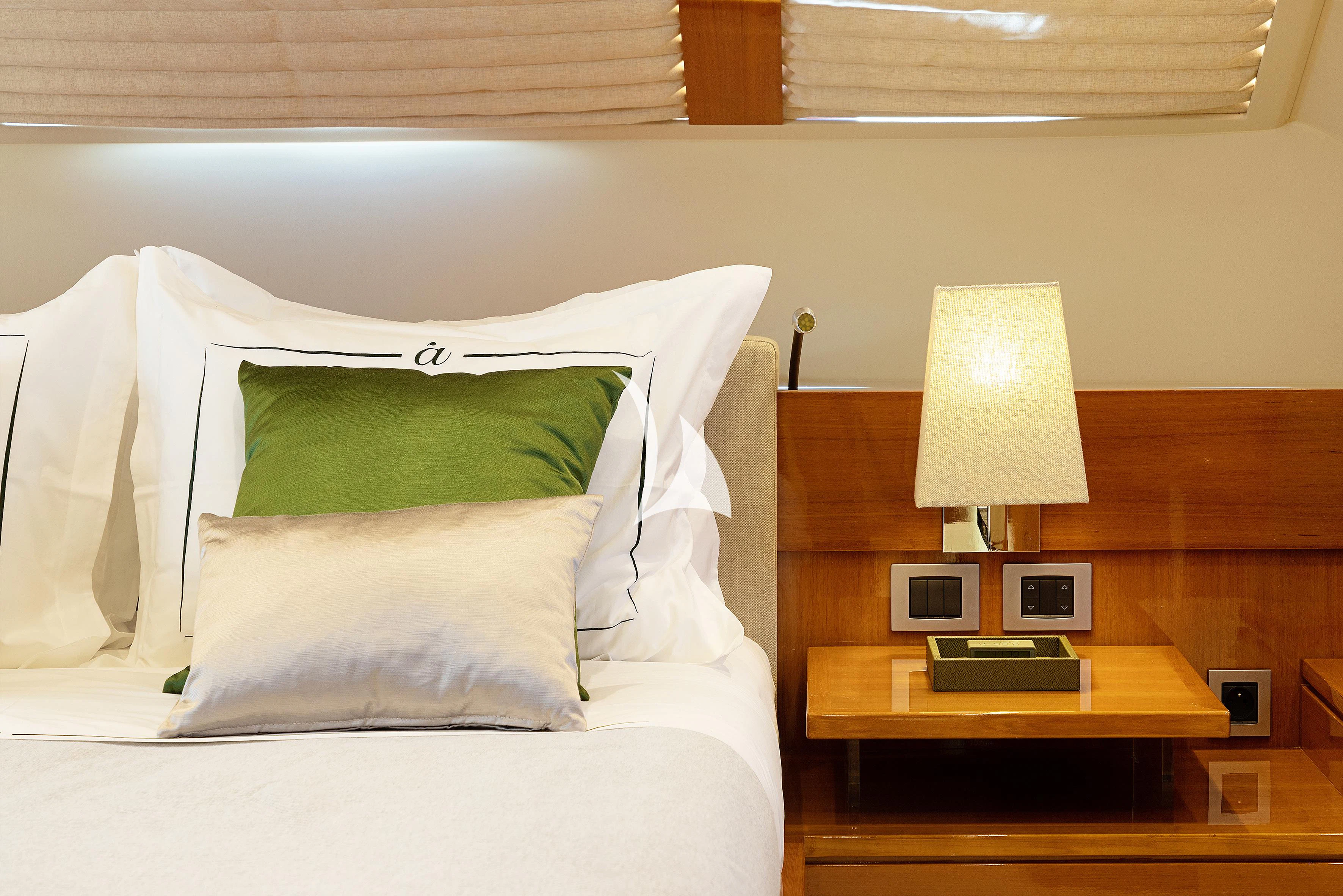 a bed with a lamp on it aboard APMONIA Yacht for Sale