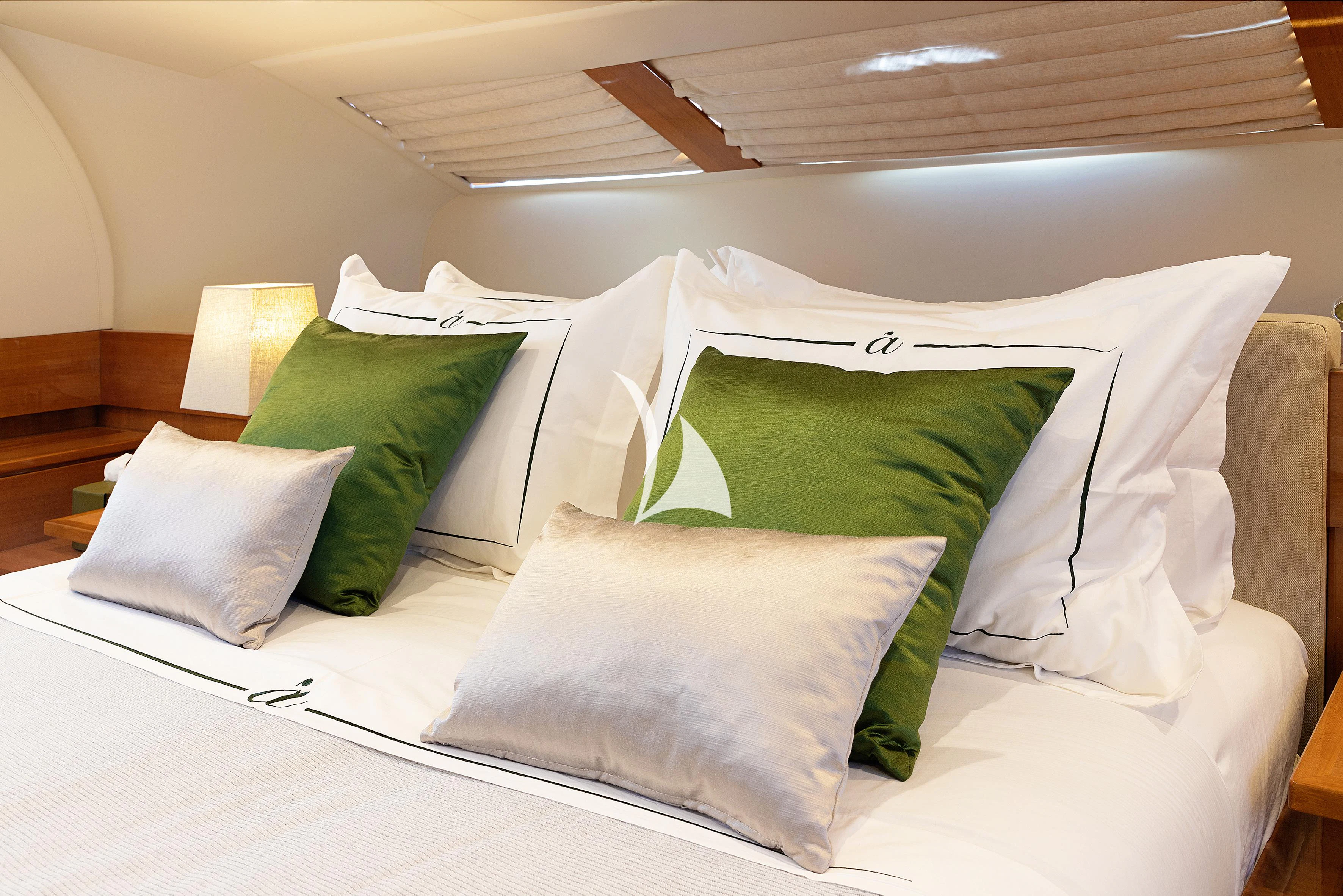 a bed with white sheets and pillows aboard APMONIA Yacht for Sale