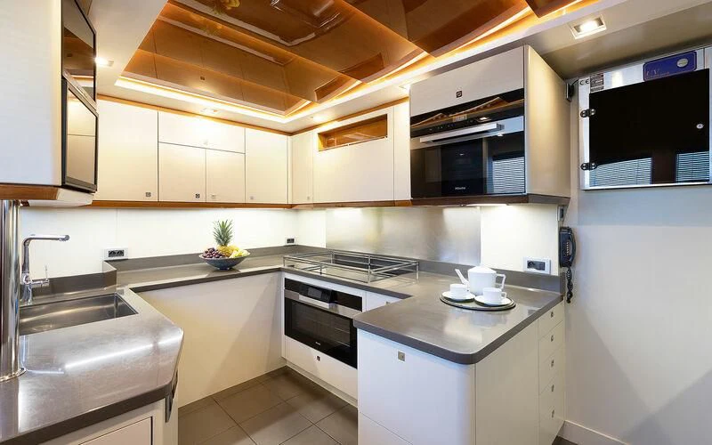 a kitchen with white cabinets aboard APMONIA Yacht for Sale