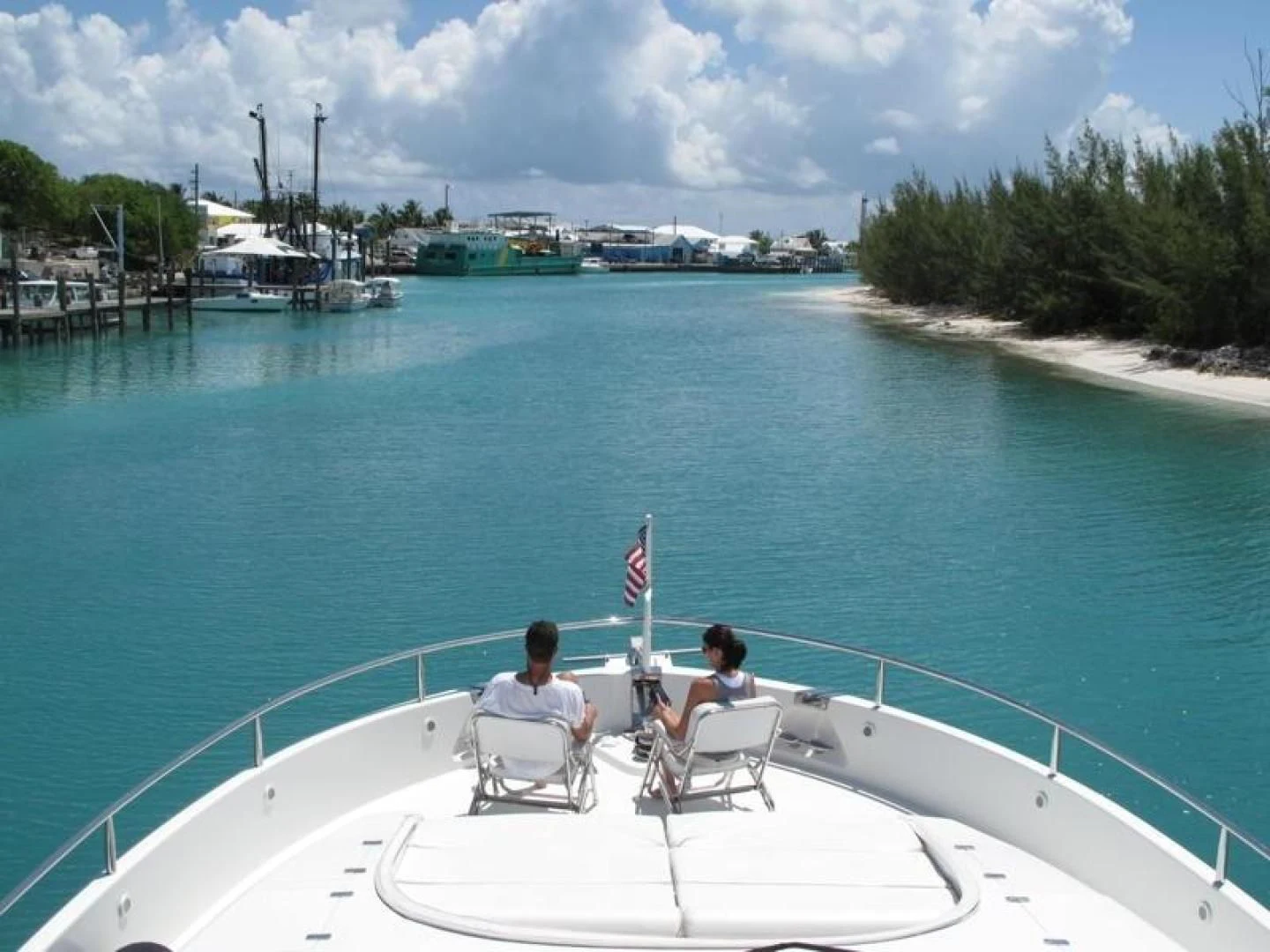 a couple sitting on chairs on a boat in the water aboard COMPANIONSHIP Yacht for Sale