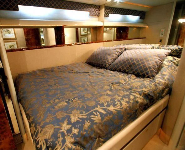a bed with blue sheets aboard COMPANIONSHIP Yacht for Sale