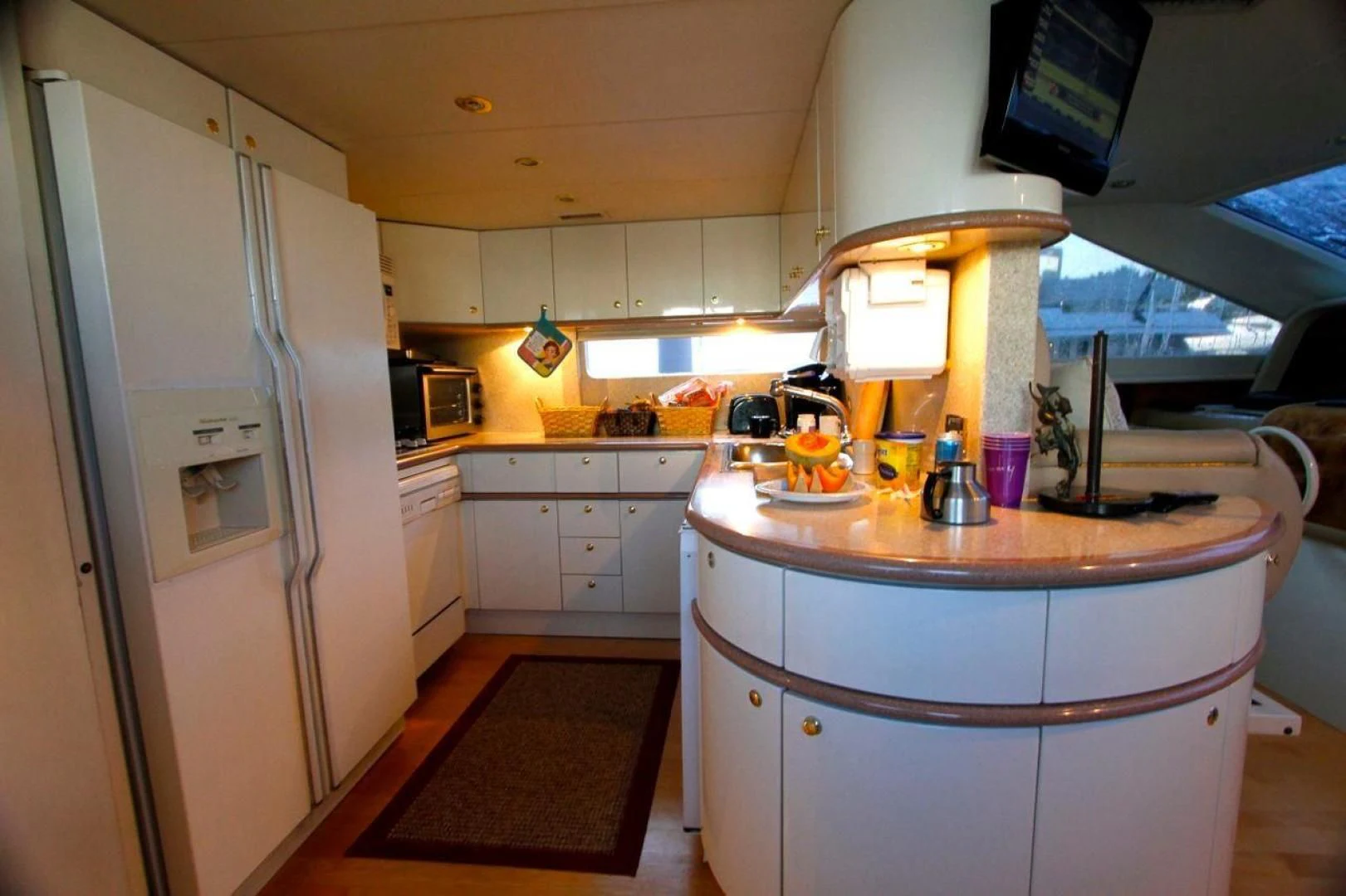a kitchen with a countertop sink and refrigerator aboard COMPANIONSHIP Yacht for Sale