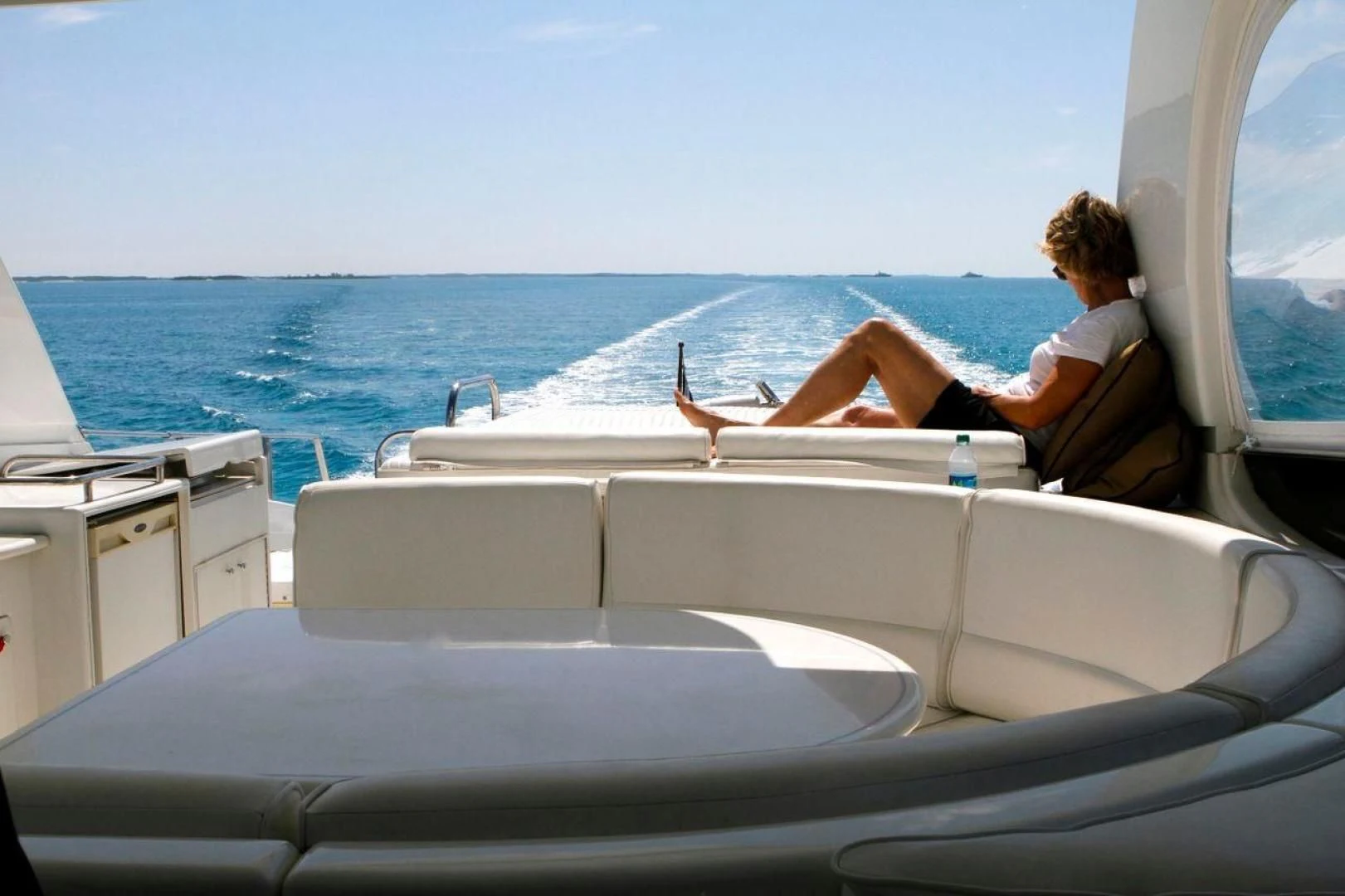 a person sitting on a boat with a dog on the water aboard COMPANIONSHIP Yacht for Sale