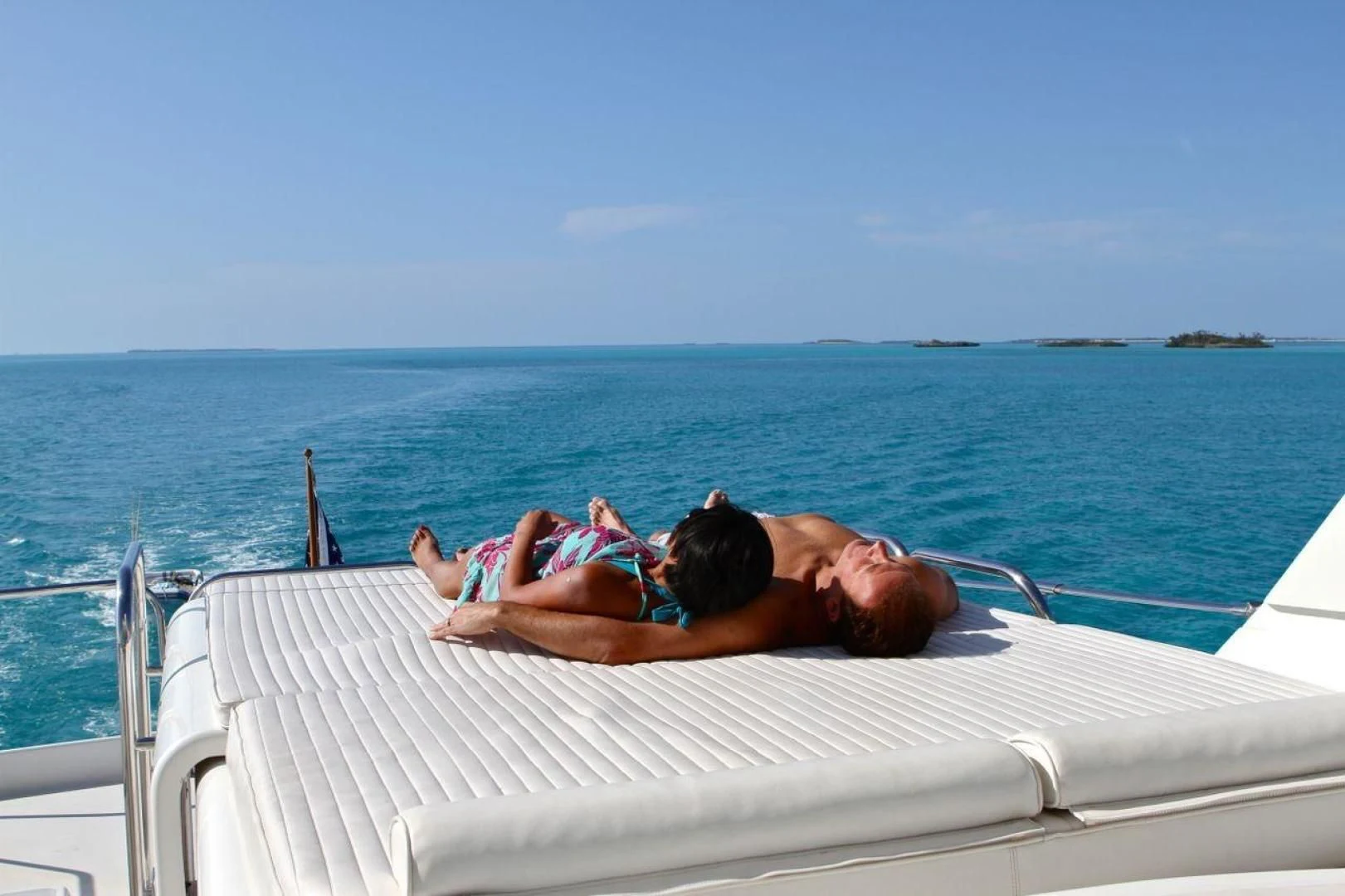 a man and a woman lying on a boat in the water aboard COMPANIONSHIP Yacht for Sale