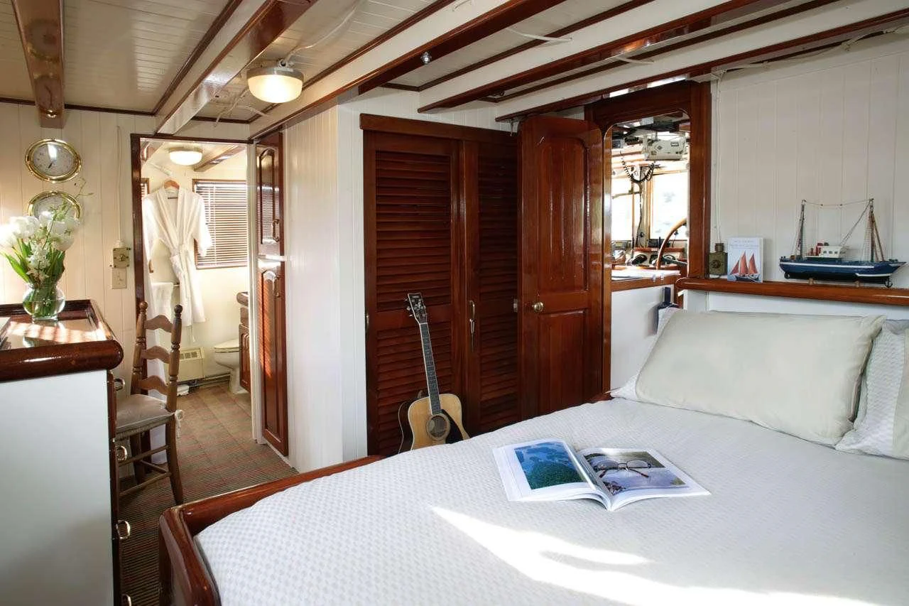 a bed with a white sheet and a laptop on it aboard PACIFIC YELLOWFIN Yacht for Sale