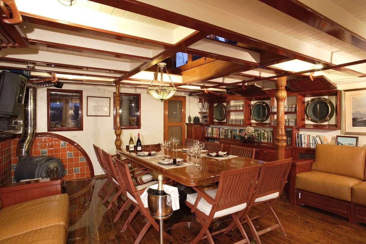 a dining room with a table and chairs aboard PACIFIC YELLOWFIN Yacht for Sale