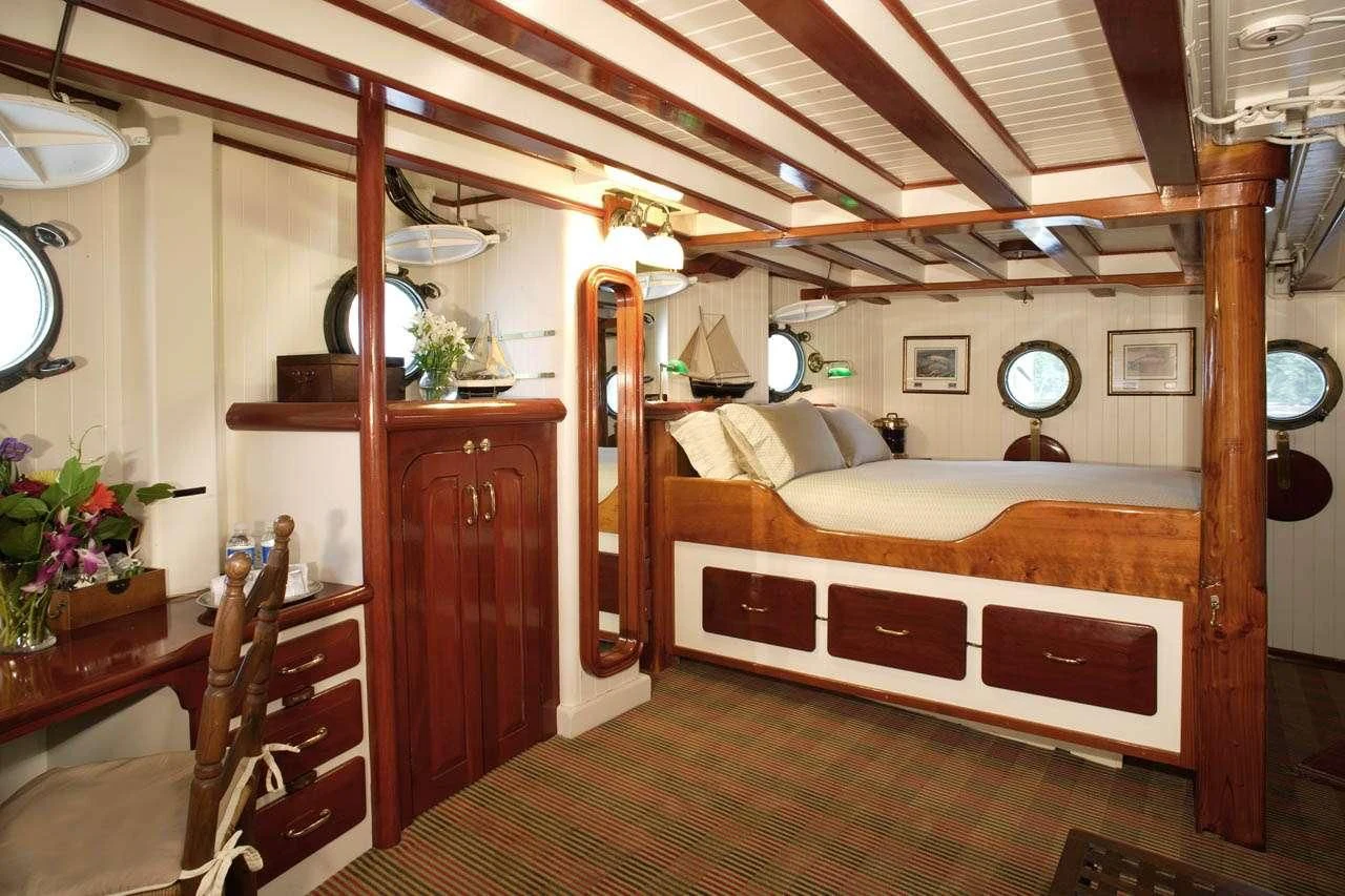 a bedroom with a bed and a desk aboard PACIFIC YELLOWFIN Yacht for Sale