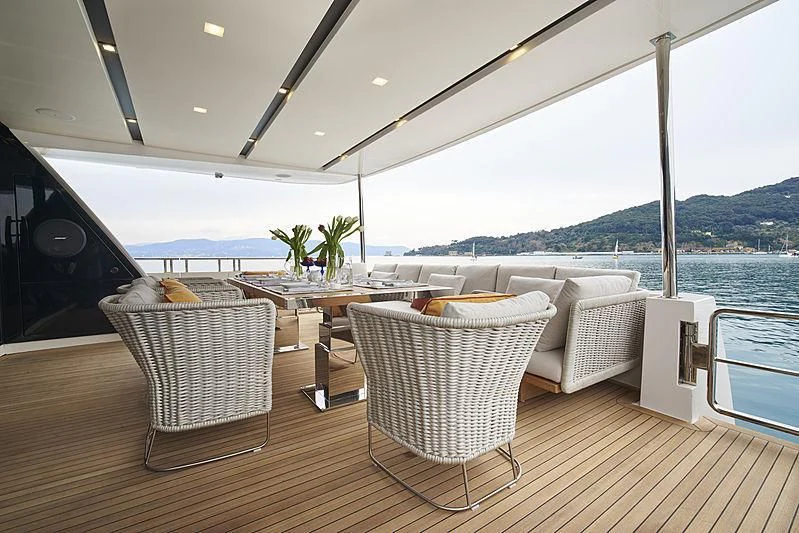 a deck with chairs and tables aboard BELLA ITALIA Yacht for Sale