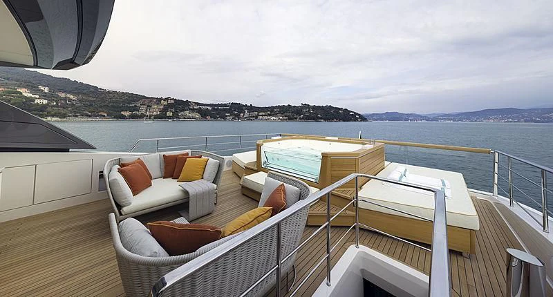 a deck with a view of the ocean and mountains aboard BELLA ITALIA Yacht for Sale