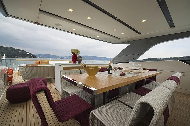 a table with chairs and a view of the ocean aboard BELLA ITALIA Yacht for Sale
