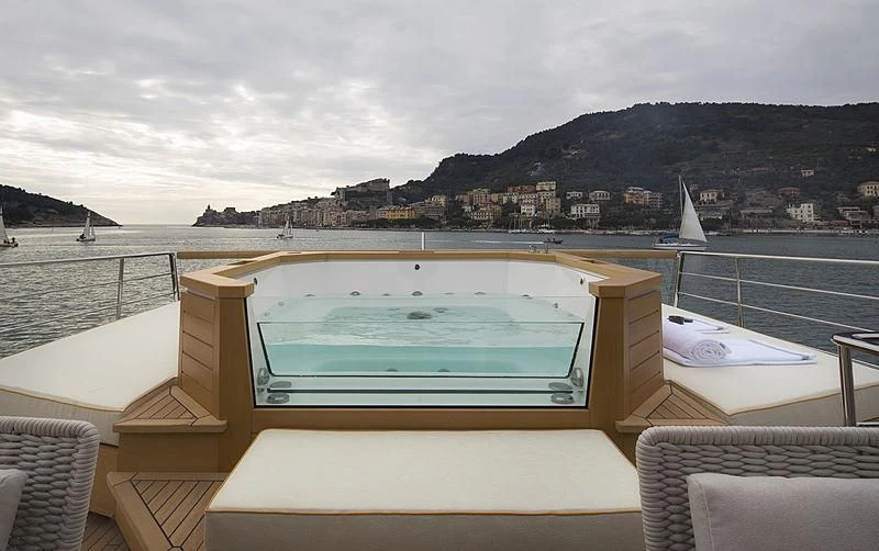 a pool on a deck overlooking a city and mountains aboard BELLA ITALIA Yacht for Sale