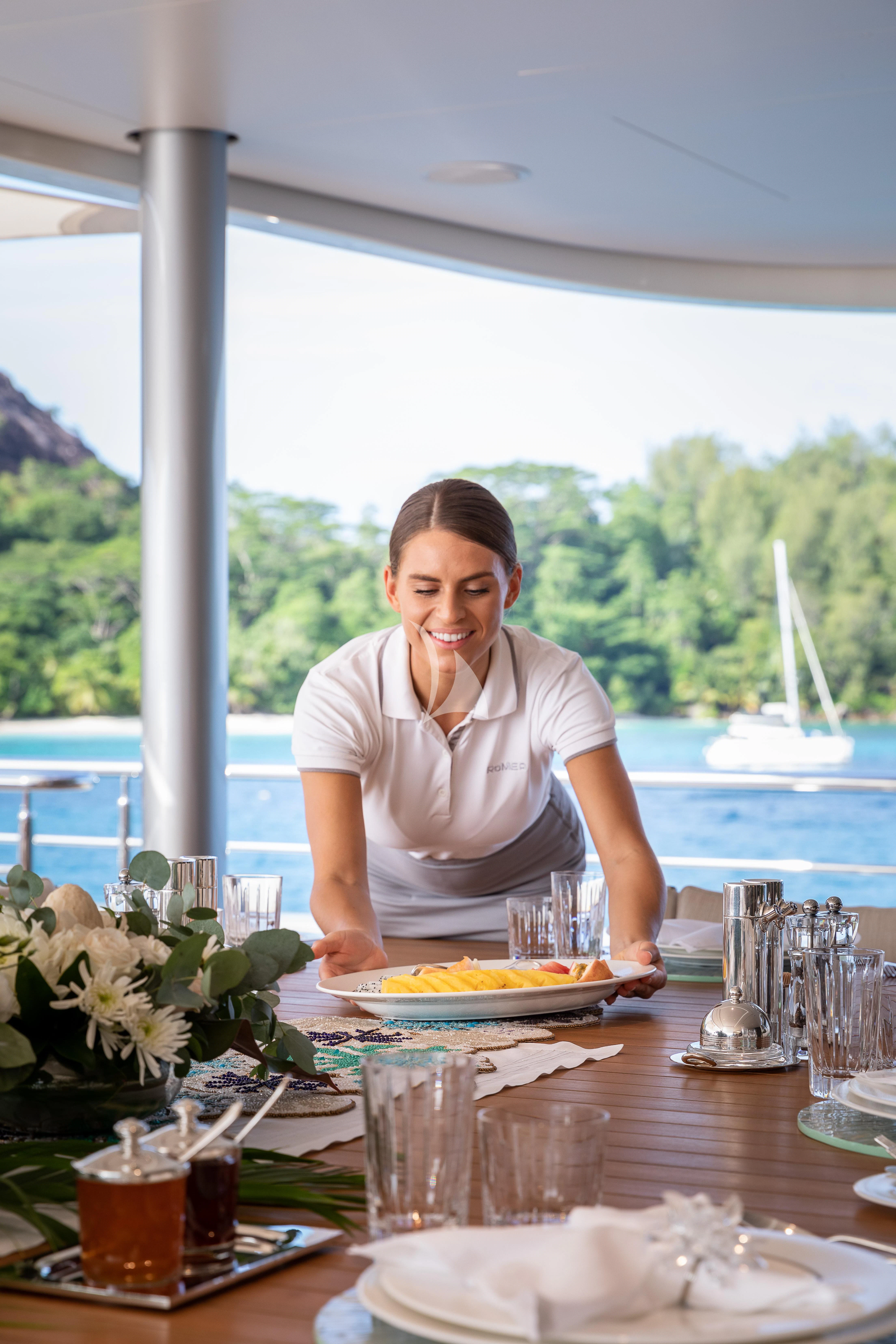 a woman holding a plate of food aboard ROMEA Yacht for Sale
