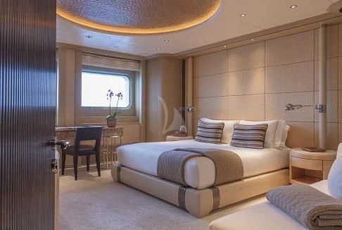 a bedroom with a bed and a desk aboard ROMEA Yacht for Sale